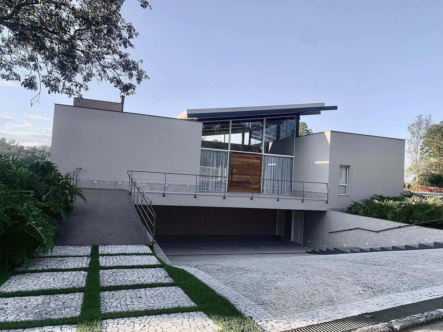 Residência contemporânea com fachada de vidro e rampa de acesso