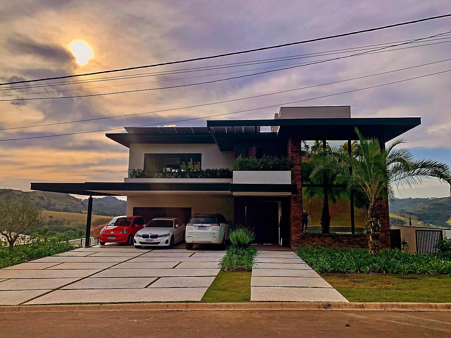 Residência de alto padrão ao entardecer com vista para a serra